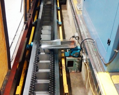 Underfloor conveyor in trench takes products from presses to packaging